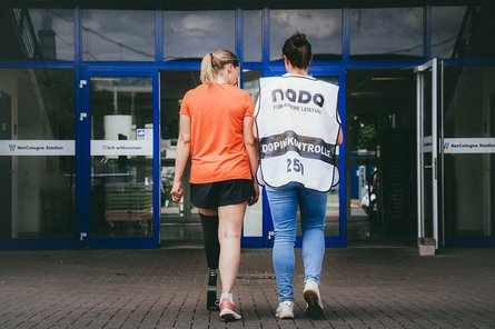 Nachgestellte Situation einer Dopingkontrolle bei einer Athletin mit einer Dopingkontrolleurin.